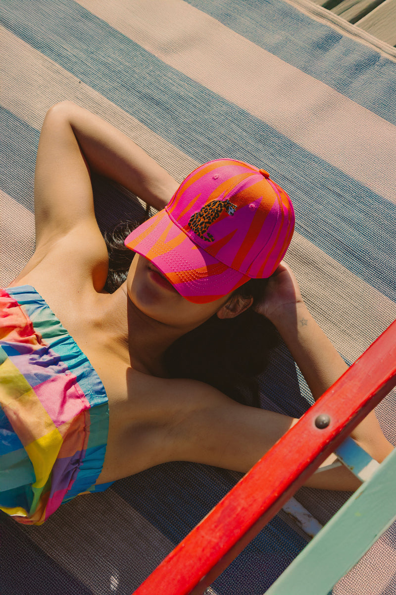 orange and pink zebra hat with leopard sitting icon